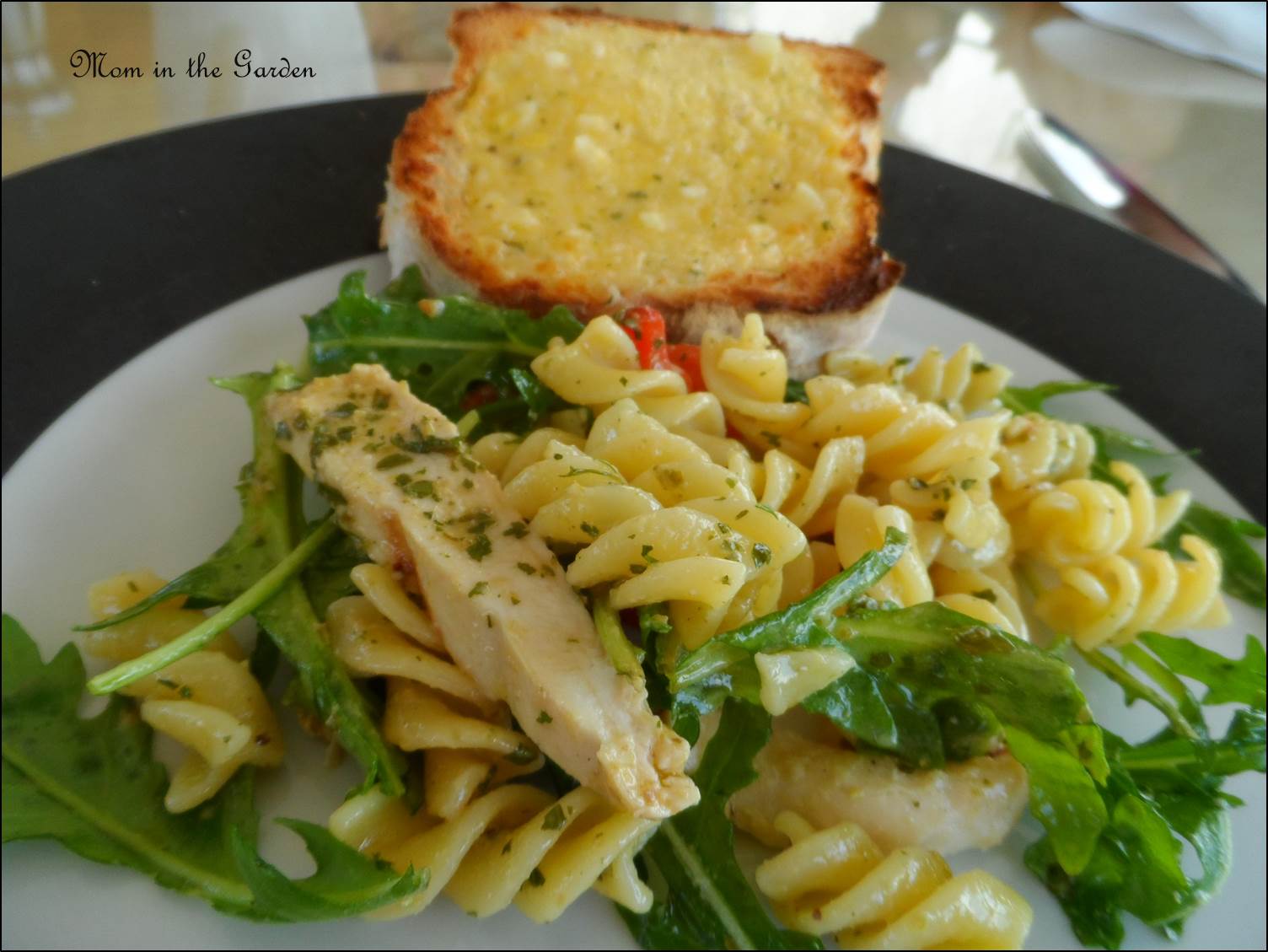 Chicken pasta salad with roasted peppers served with garlic bread