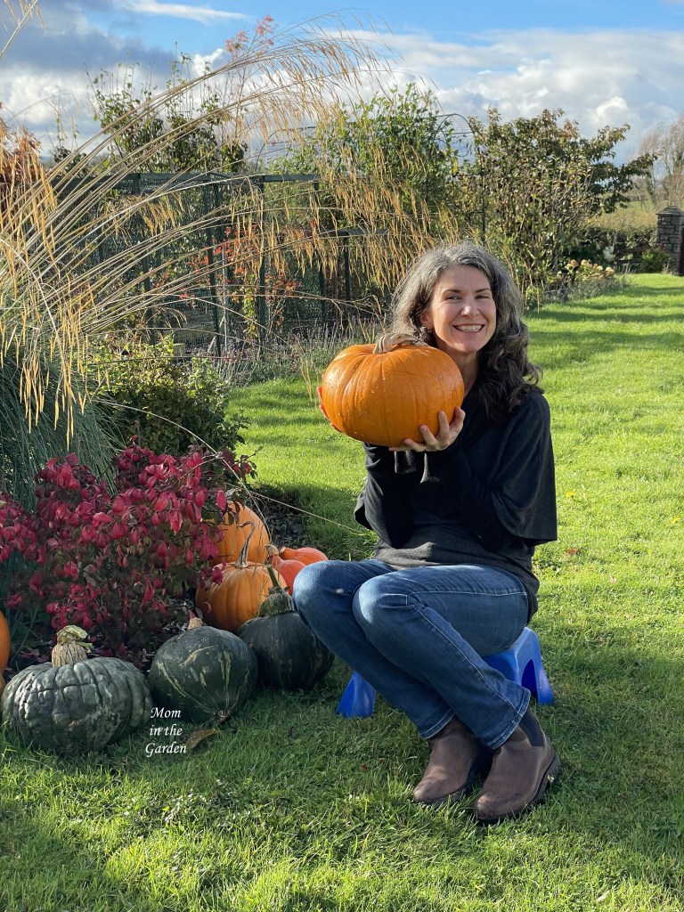 Dana with pumpkin infront of squash from this season